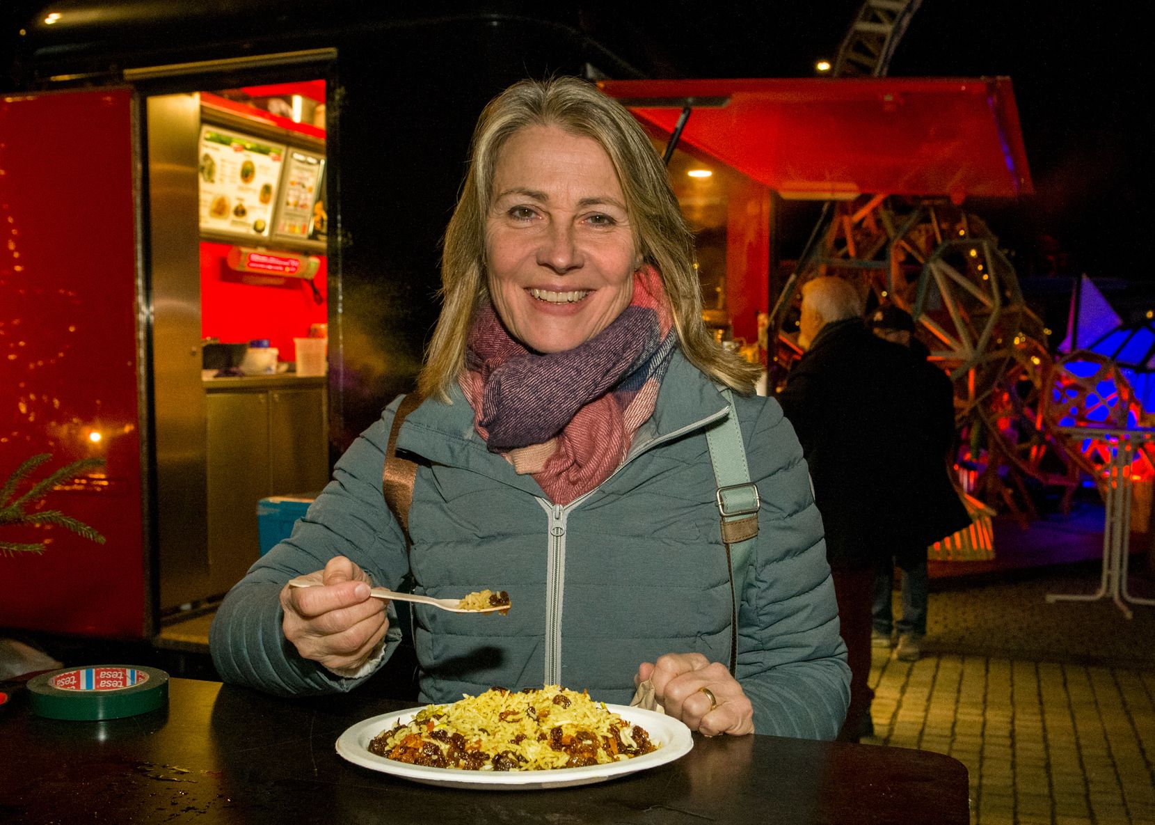 Menschen in winterlicher Kleidung beim Essen. 